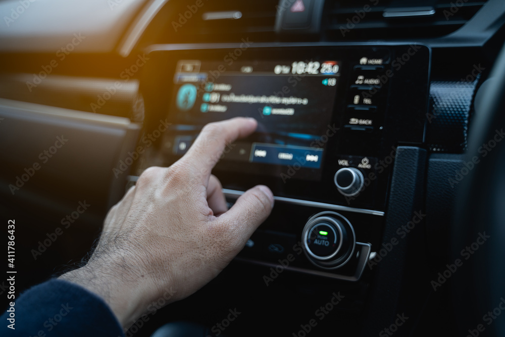 the driver using touch screen monitor in the modern car